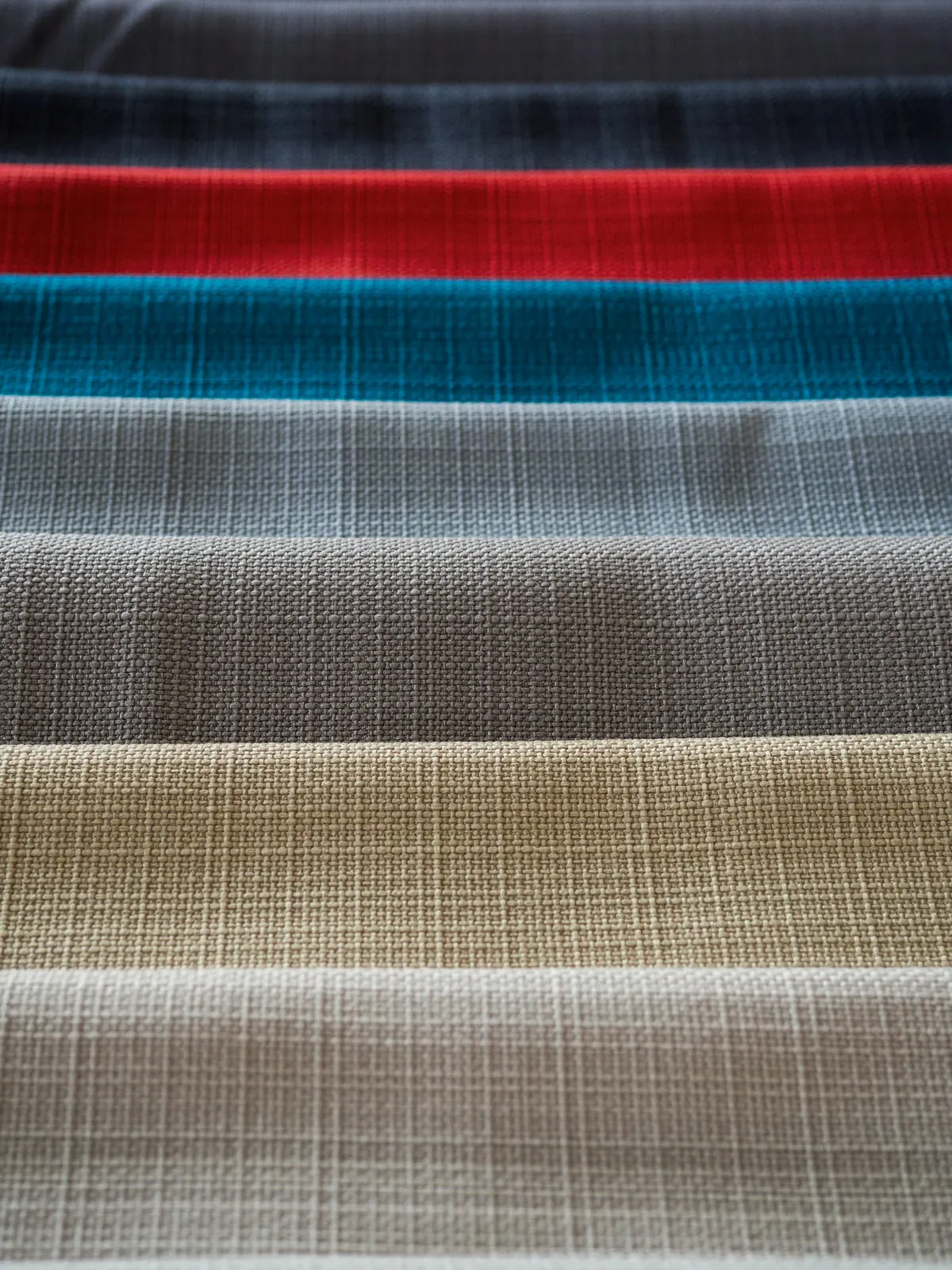 Stacked fabric swatches representing a range of wholesale textile materials